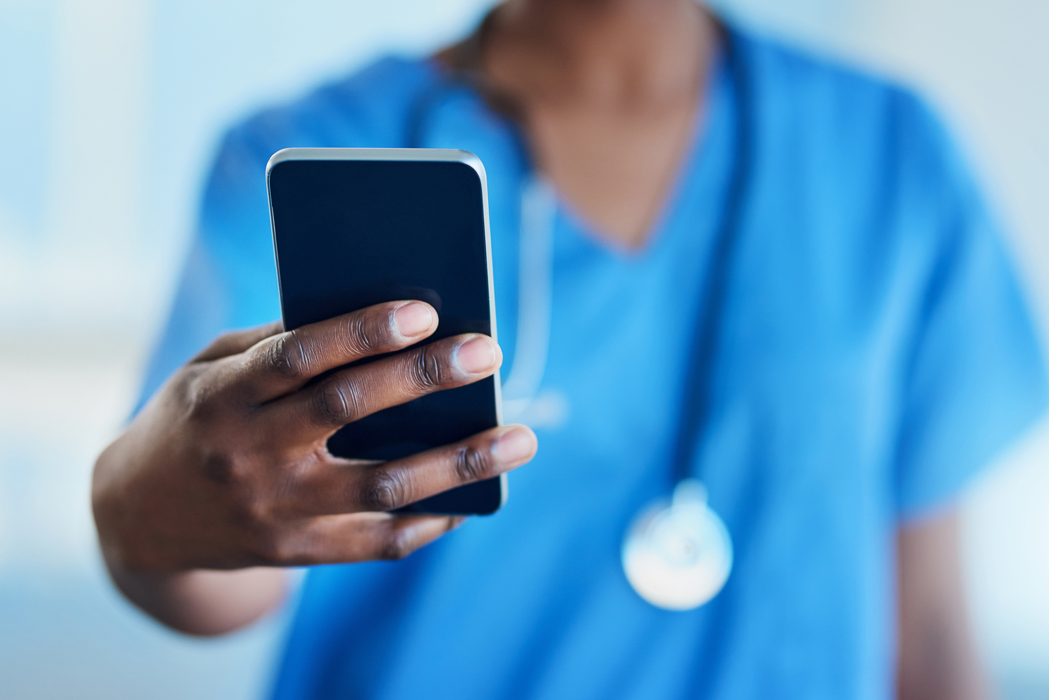 Closeup shot of an unrecognizable nurse using a cellphone in a hospital