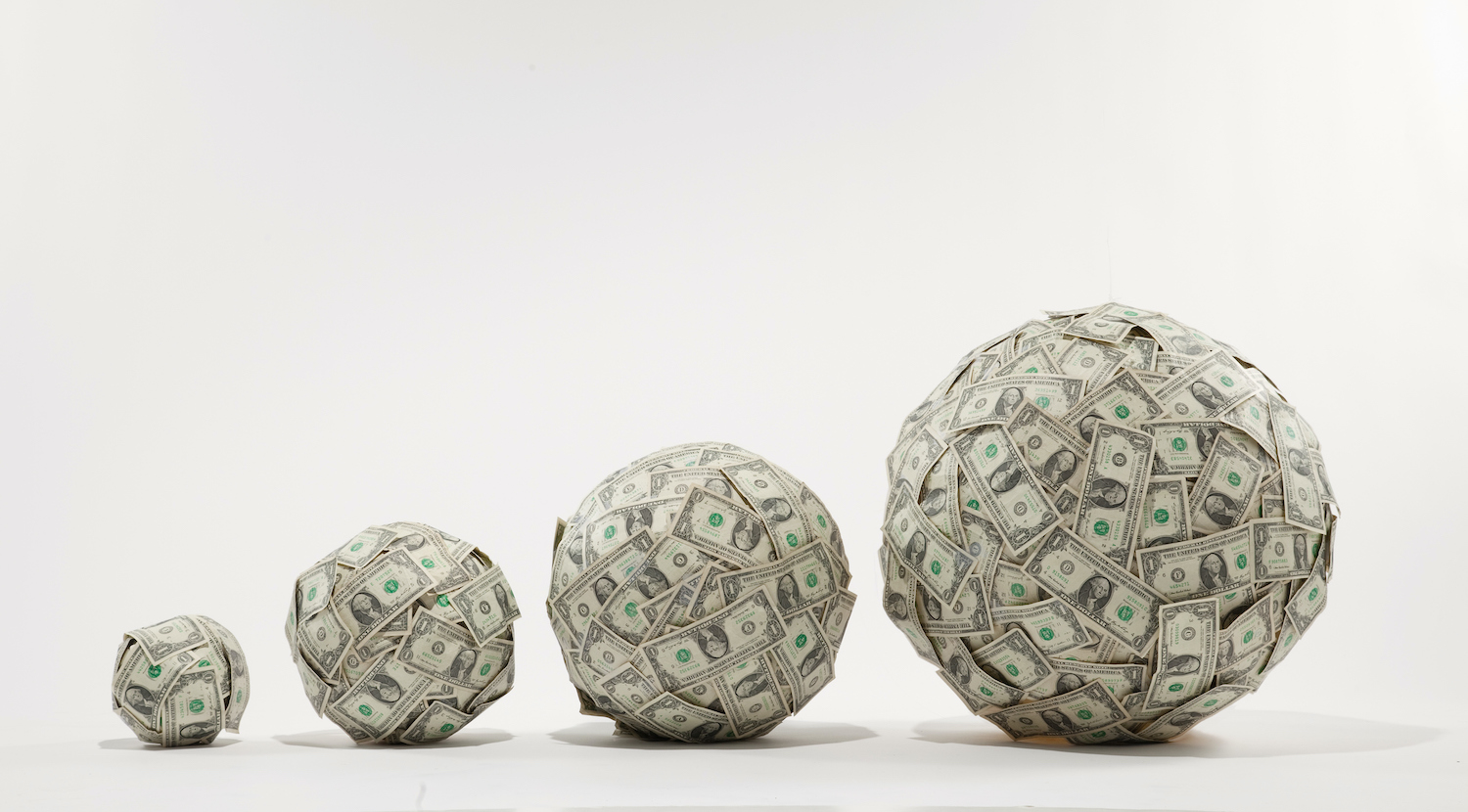 4 progressively larger balls of US $ 1 bills, studio shot